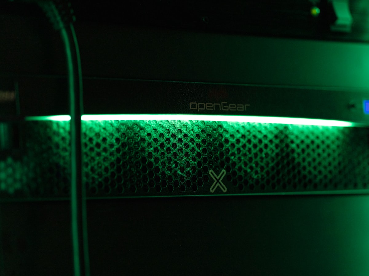 A glowing green indicator light in a server room