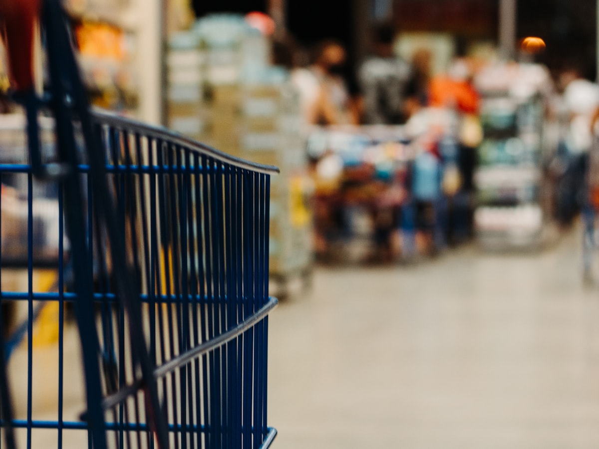 A shopping cart in a busy store aisle
